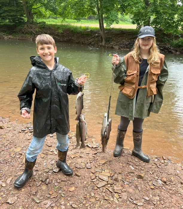 Two children holding fish caught at the MITER Brands Rodeo